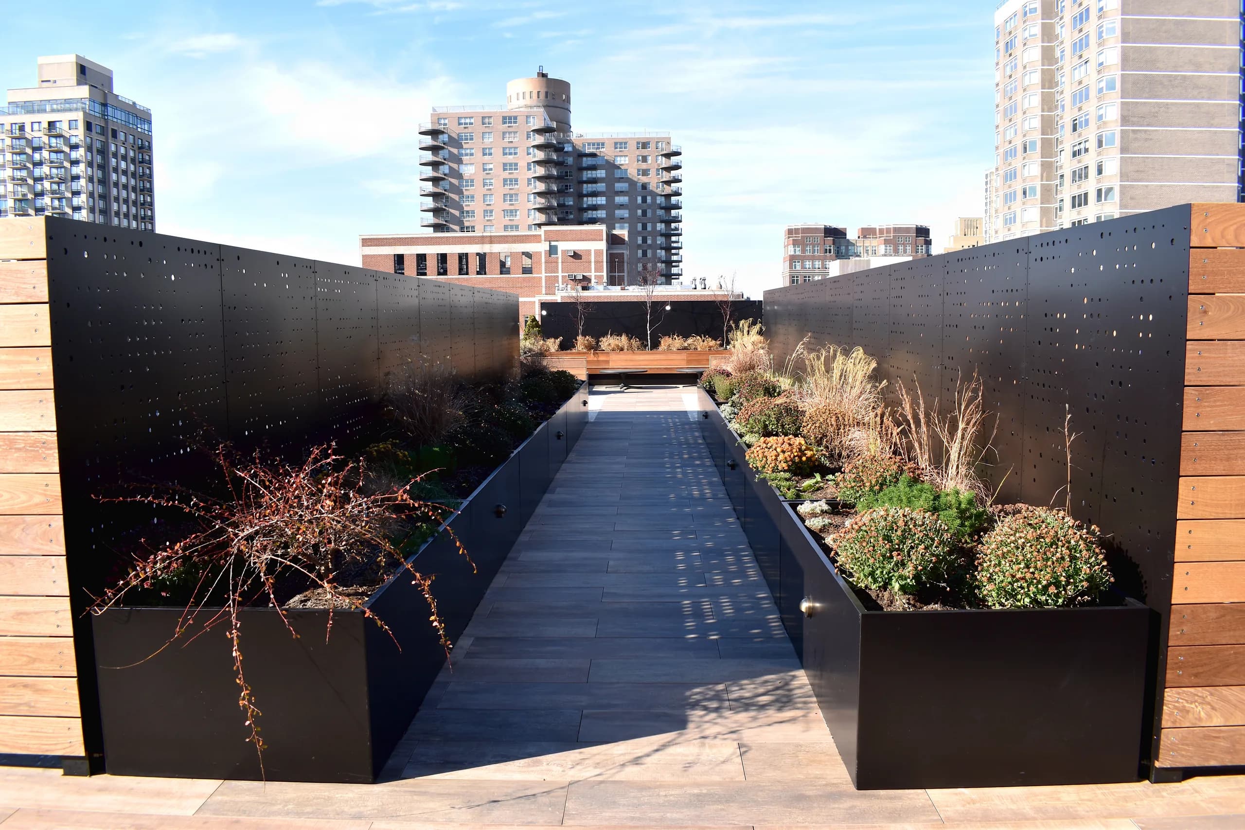 Planted rooftop walkway with perforated metal screens
