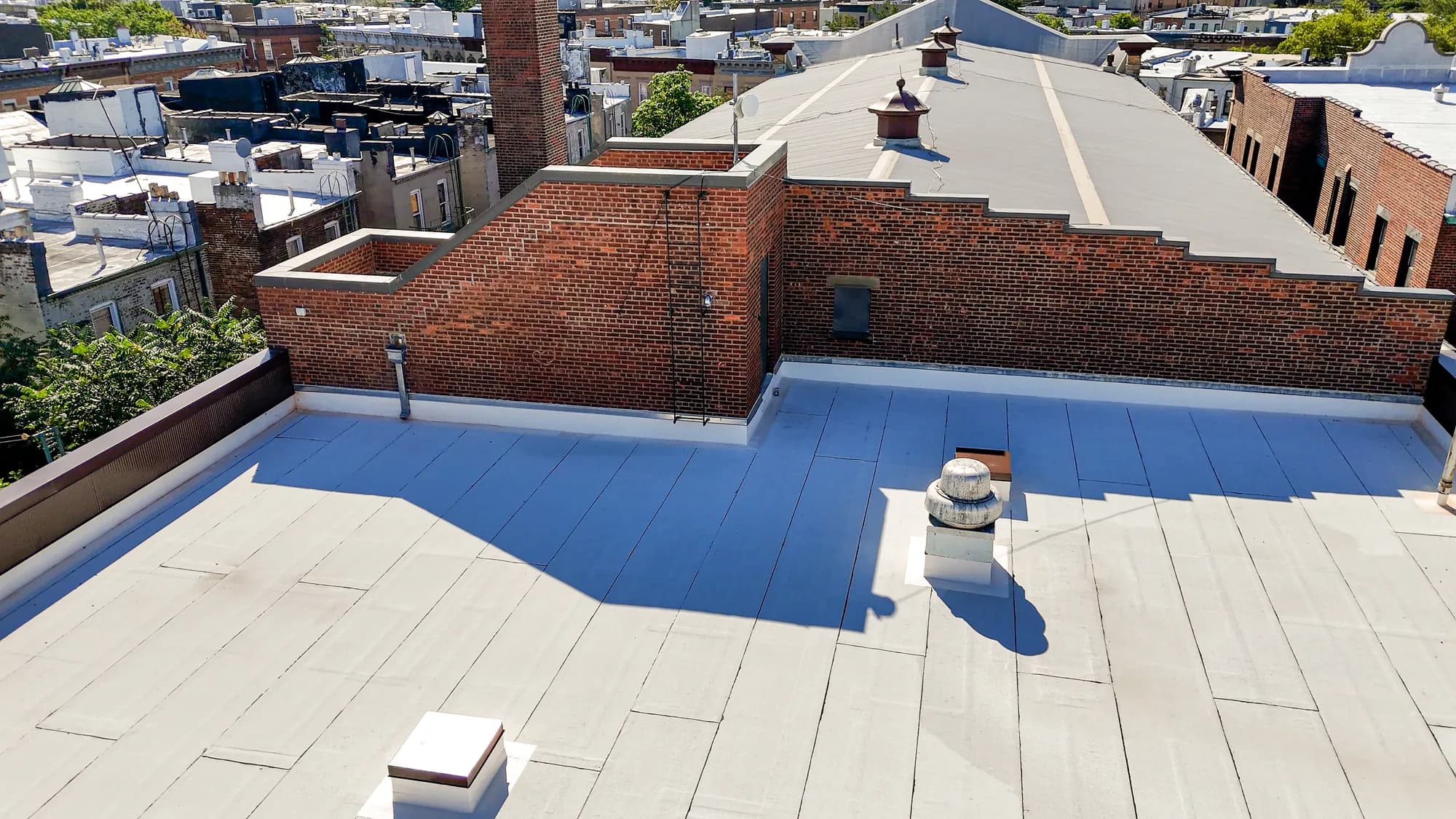 Detailed aerial view of the finished roofing surface and rooftop penetrations