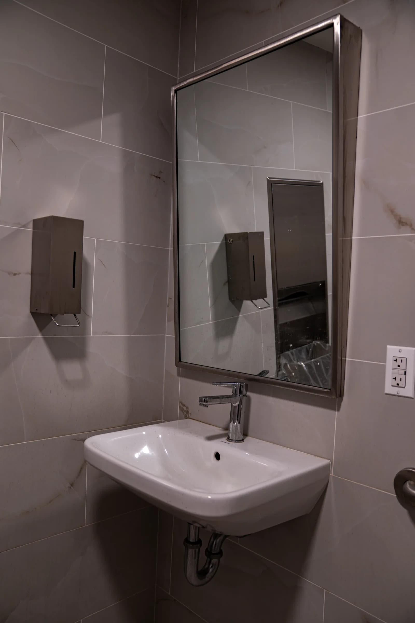 Accessible wall-mounted sink and mirror in the renovated restroom