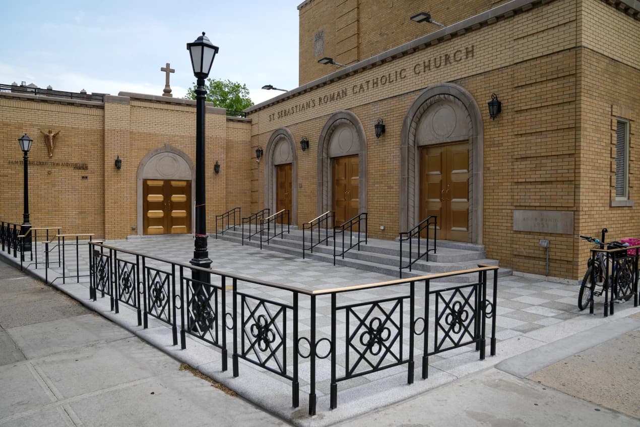 Completed church entrances, paved forecourt, and perimeter railings